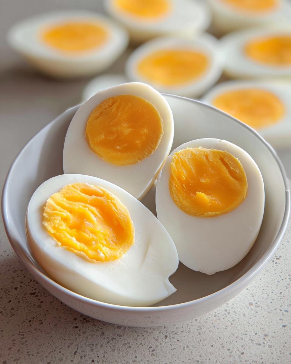 Close-up of hard-boiled eggs, halved, revealing bright yellow yolks, perfect for healthy meals recipes and meal prep.
