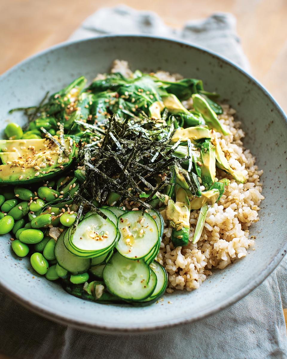 A vibrant and healthy rice bowl featuring brown rice, sliced avocado, edamame, cucumber, and seaweed, perfect for a beginner's guide to rice bowls.