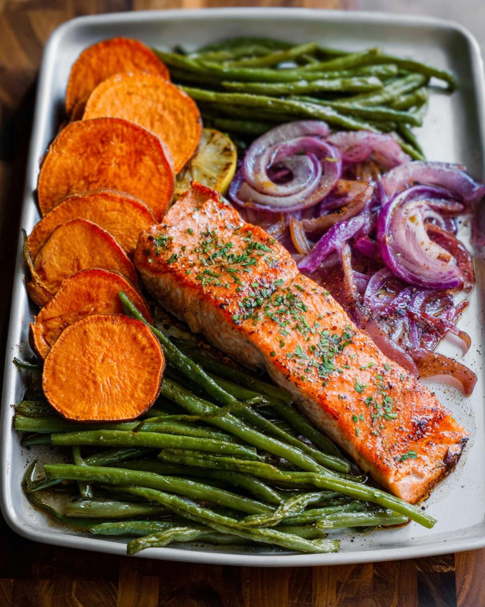 A perfectly cooked salmon fillet with roasted sweet potatoes, green beans, and red onions, ideal for Salmon Recipes Meal Prep.