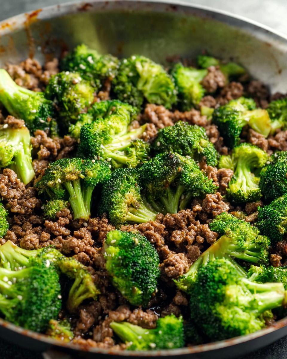 Close-up of a Keto Hamburger Broccoli Skillet with seasoned ground beef and bright green broccoli florets, sprinkled with sesame seeds.