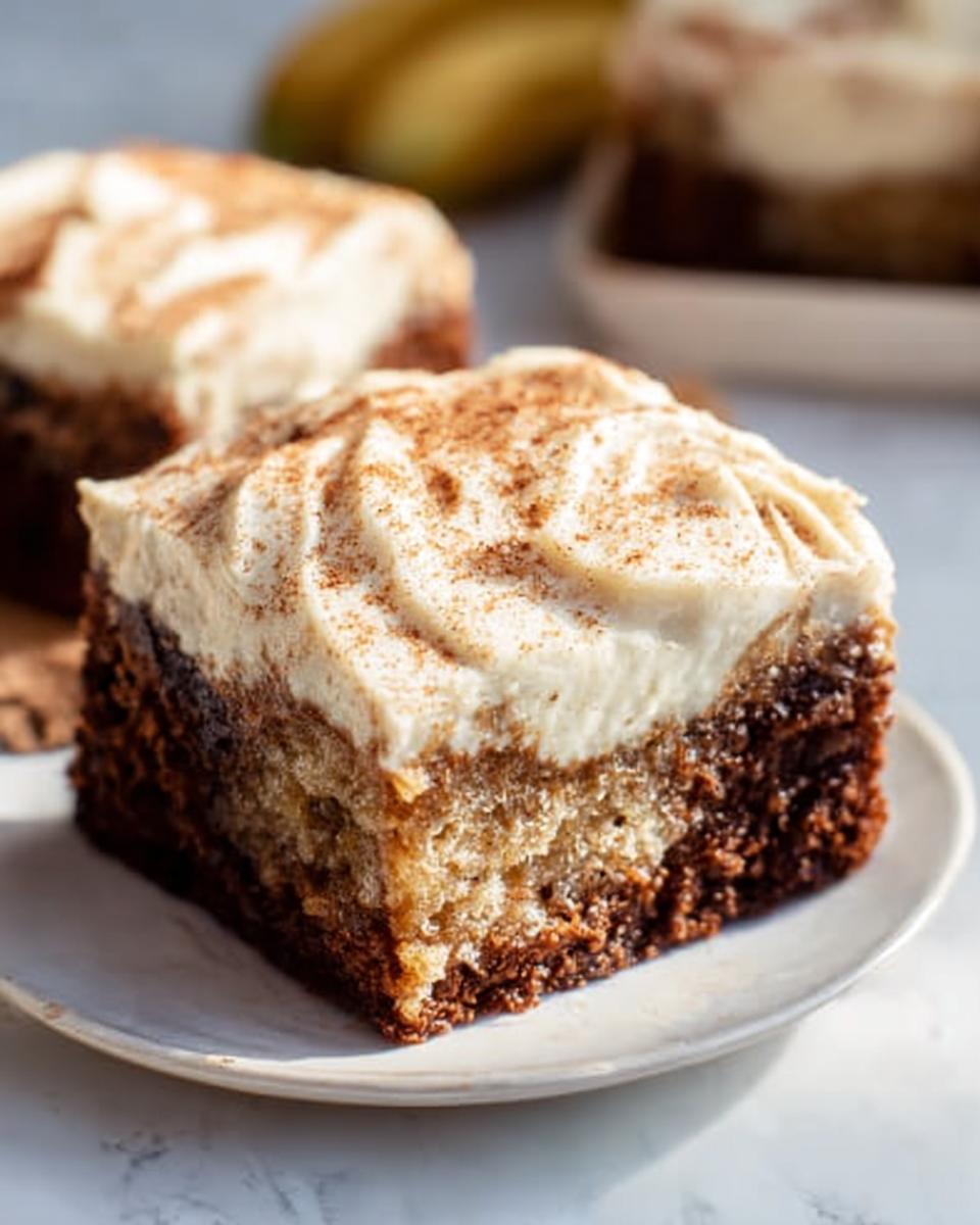 A close-up of a slice of Banana Bread Brownies Made Easy, topped with creamy frosting and a sprinkle of cinnamon.