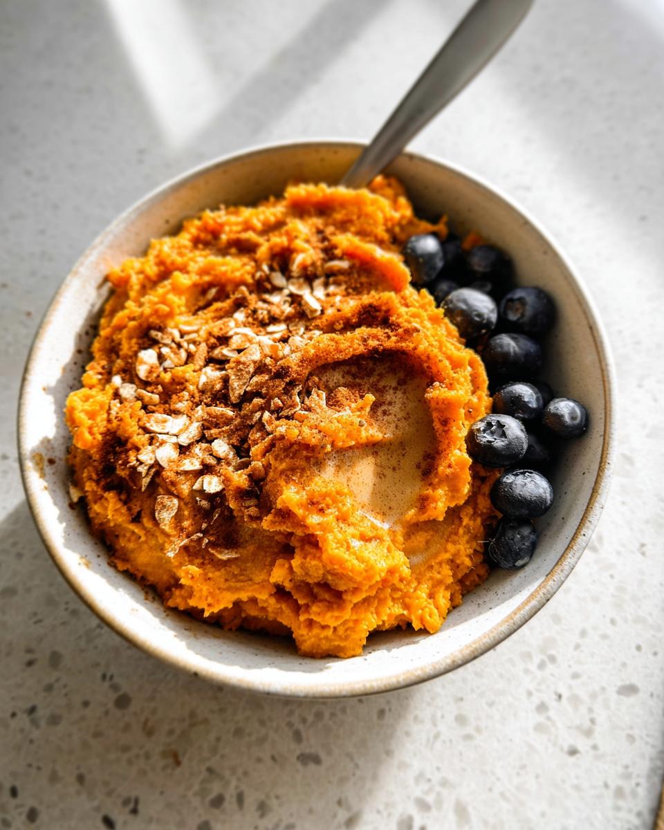 A Delicious Sweet Potato Breakfast Bowl topped with blueberries, oats, and cinnamon.
