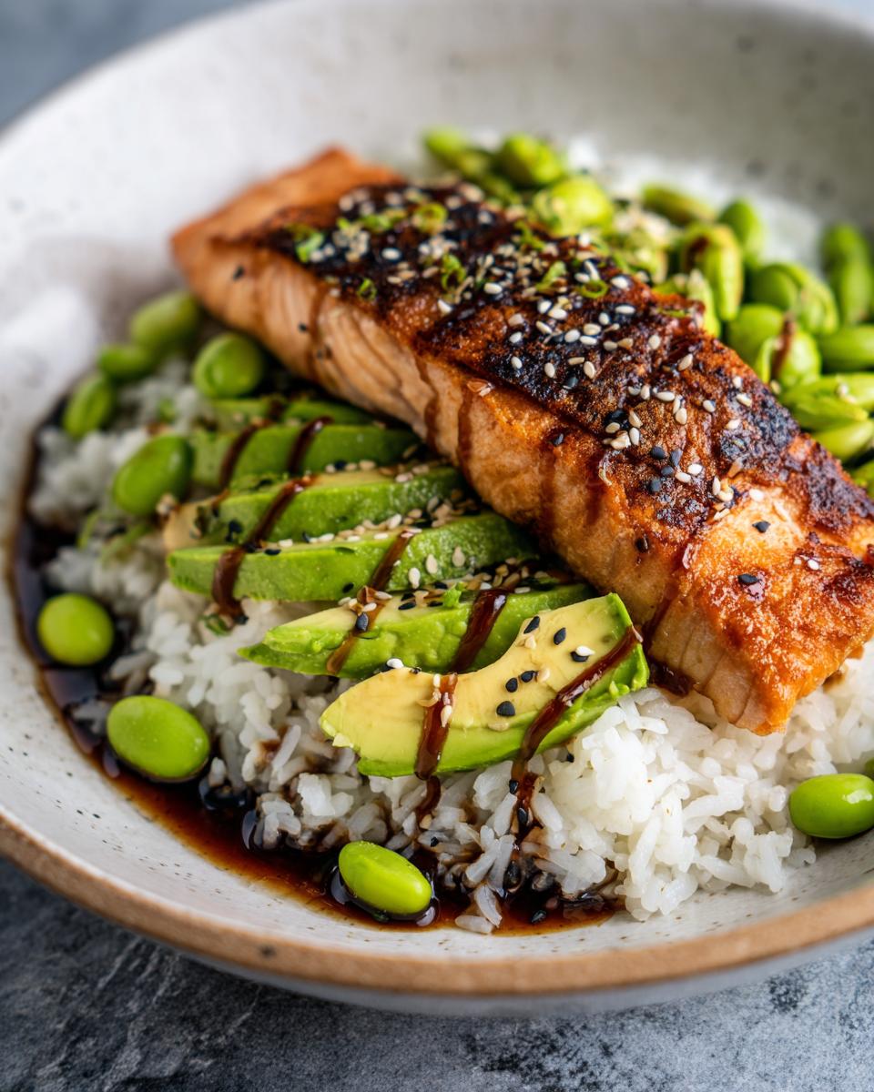 A delicious Crispy Salmon and Rice Bowl with sliced avocado, edamame, and sesame seeds.